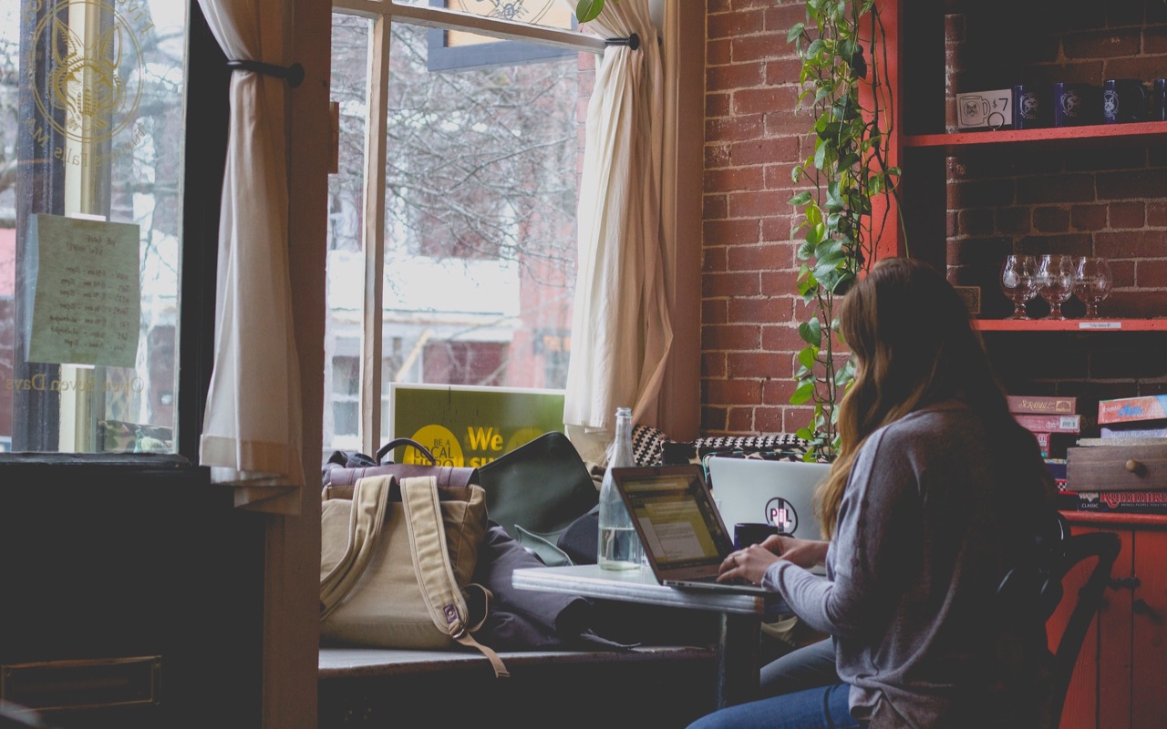 A businesswoman working on a laptop, managing her service arbitrage business.