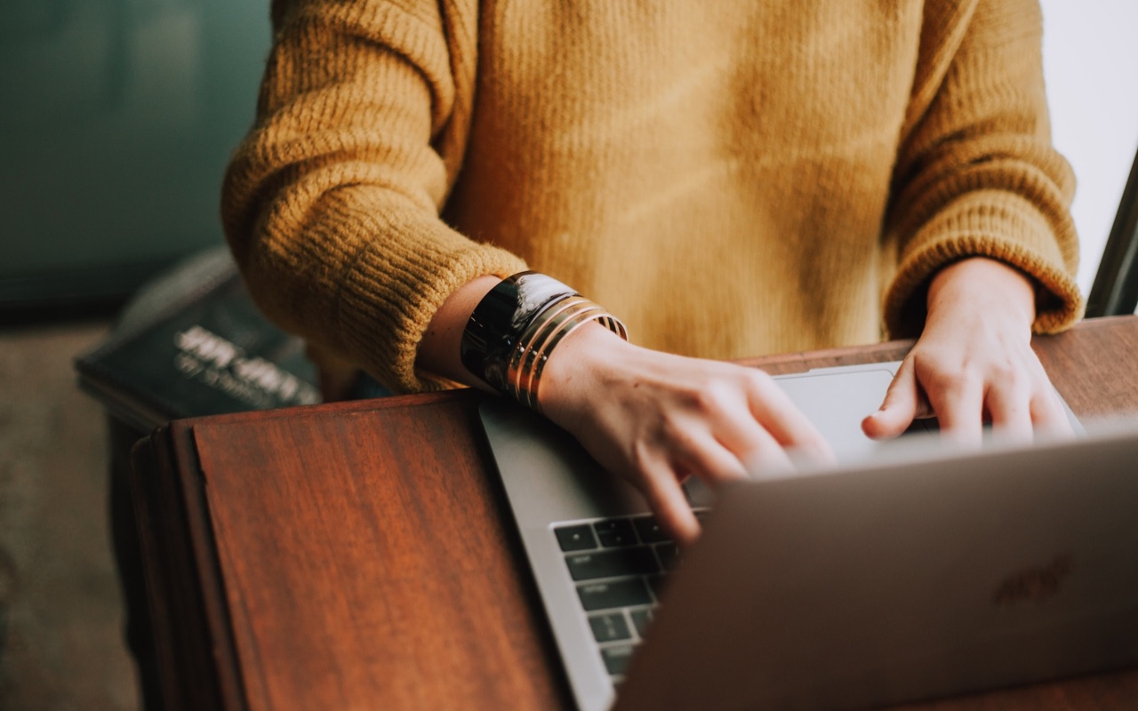 A woman typing ad copy on a laptop