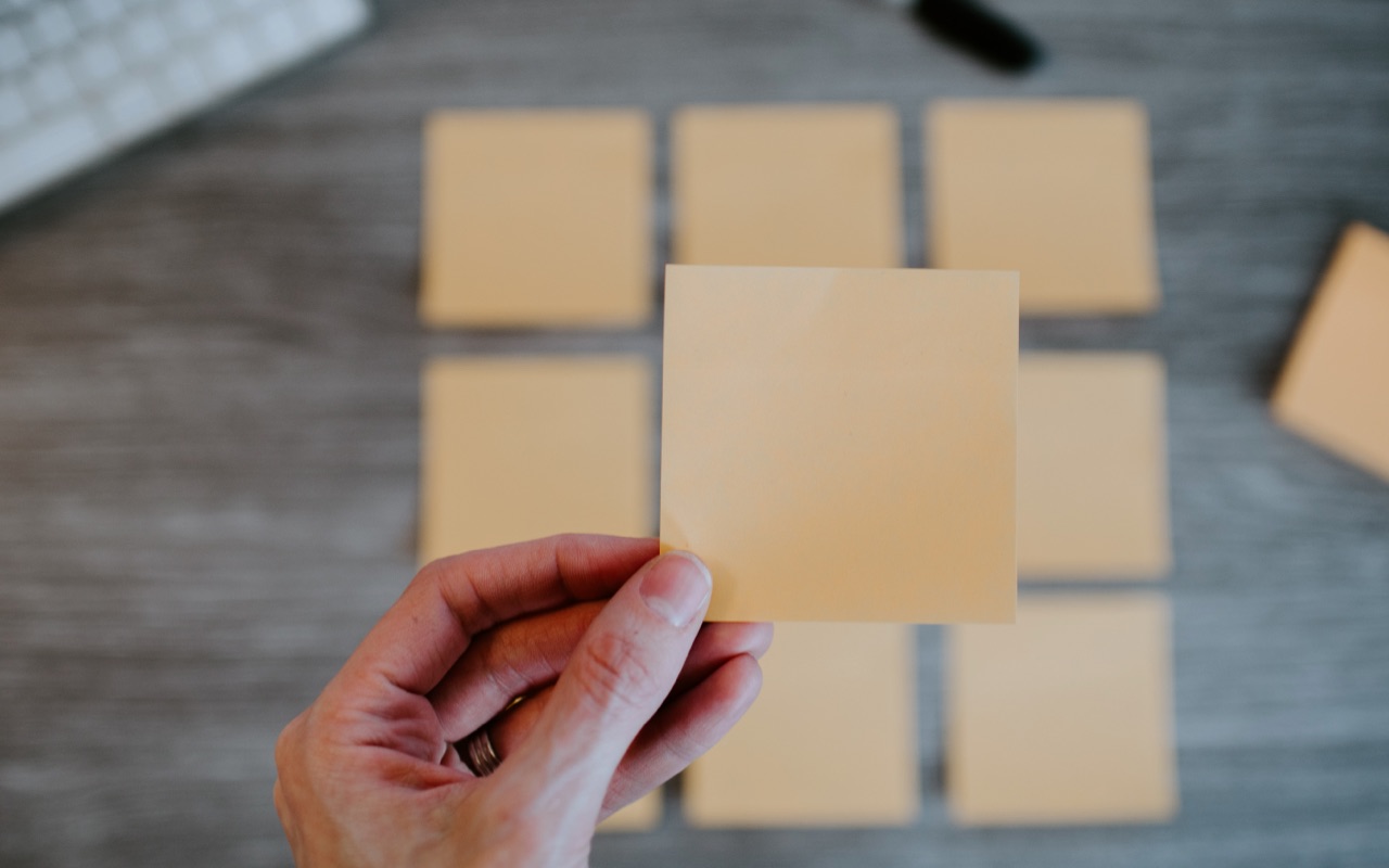 A woman holding an empty post-it note