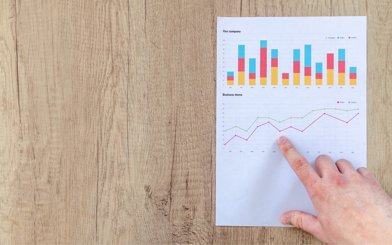 A man pointing to a figure on a financial report on a table