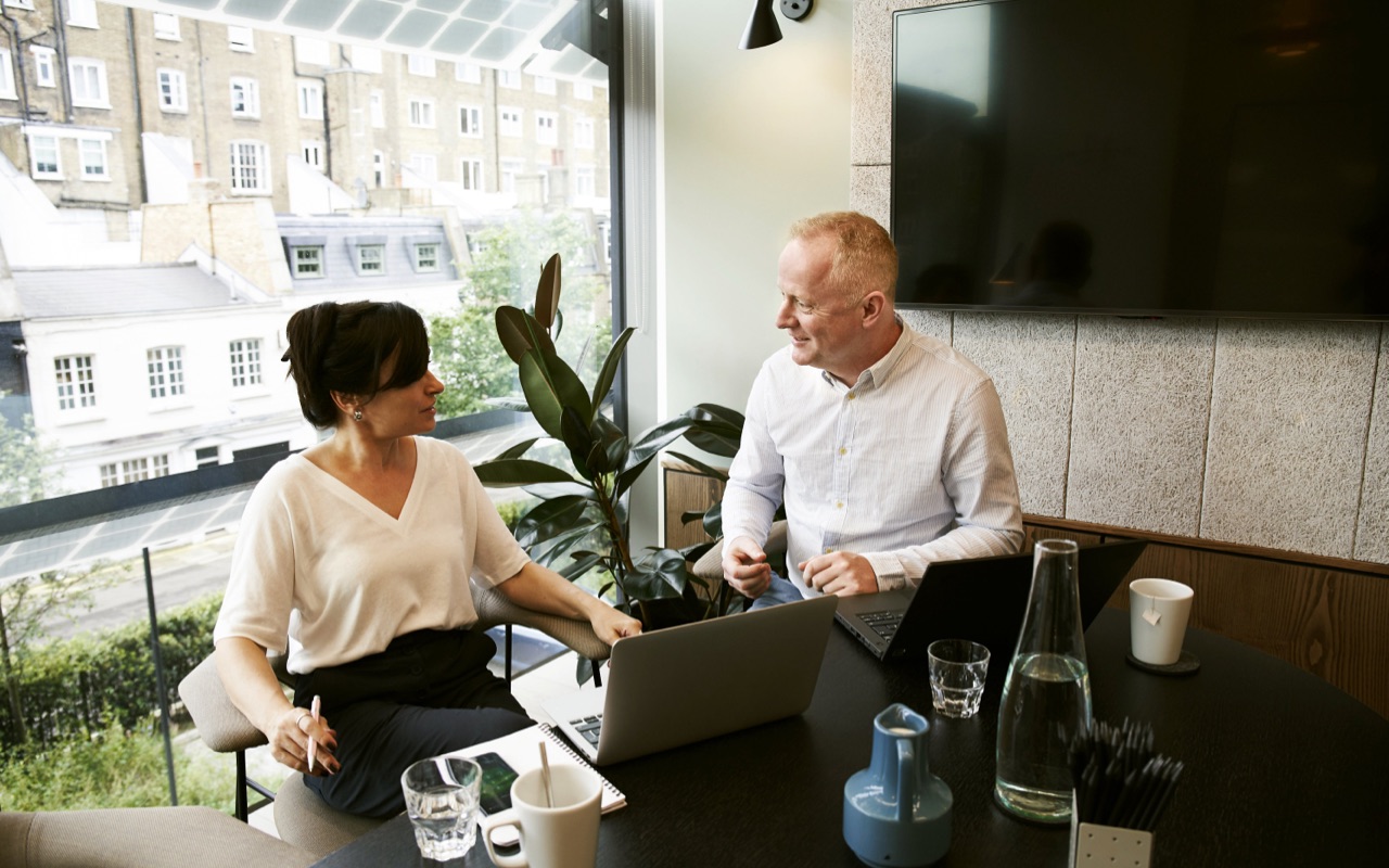 A client meeting where a man and a woman discusses travel expense policy