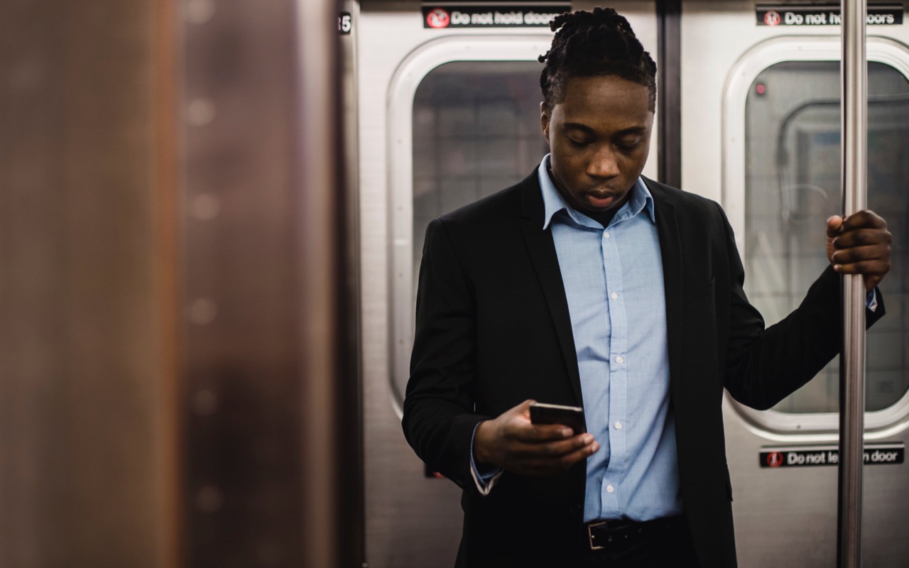 A man checking entering expenses on his phone in a train