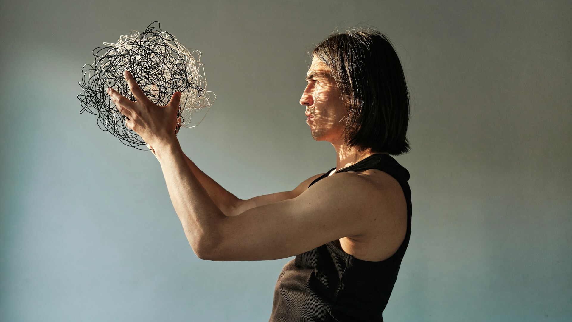 A man holding a mess of wires in front of his face