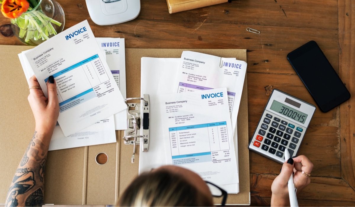 Woman checking invoices at her desk.