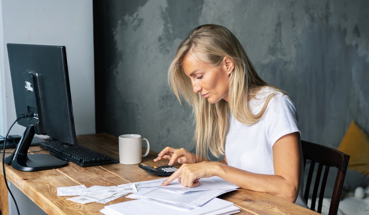 Woman reviewing invoices at her desk.