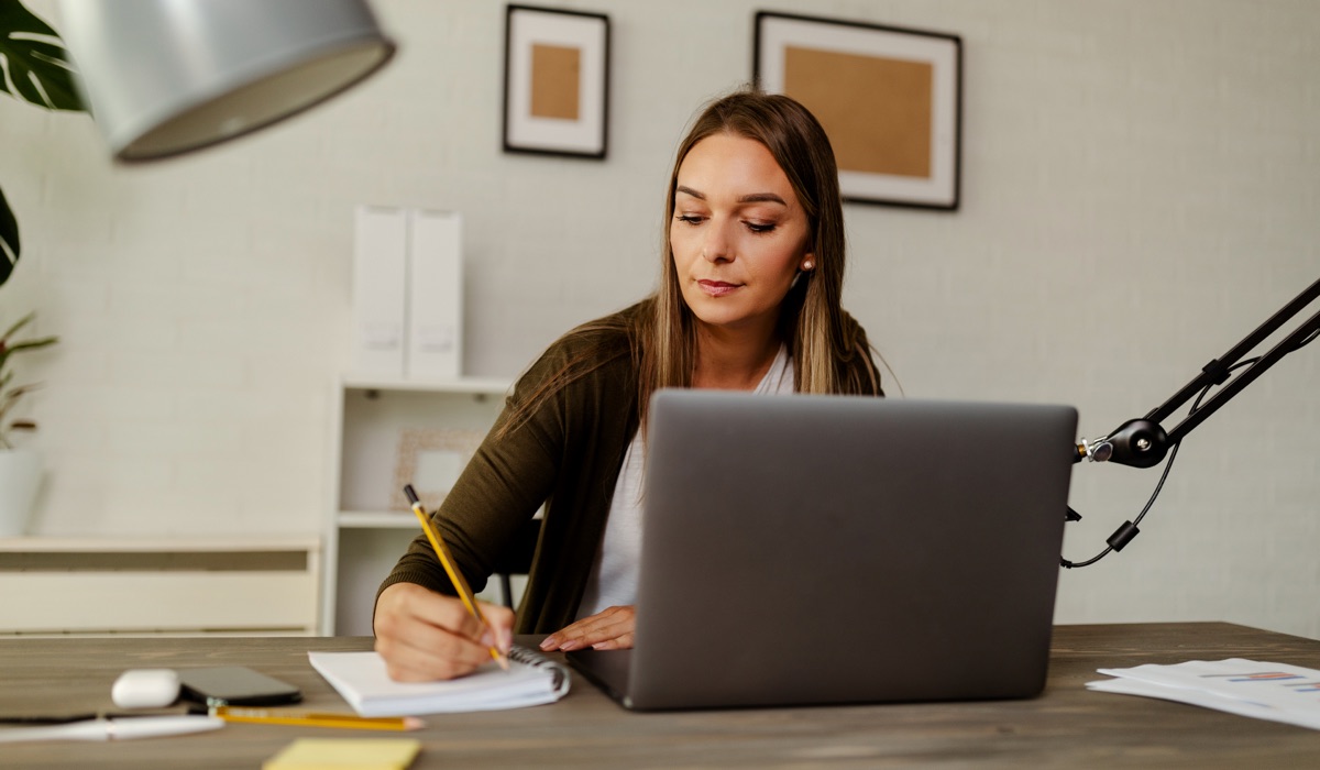 Woman at her desk, writing a design brief.