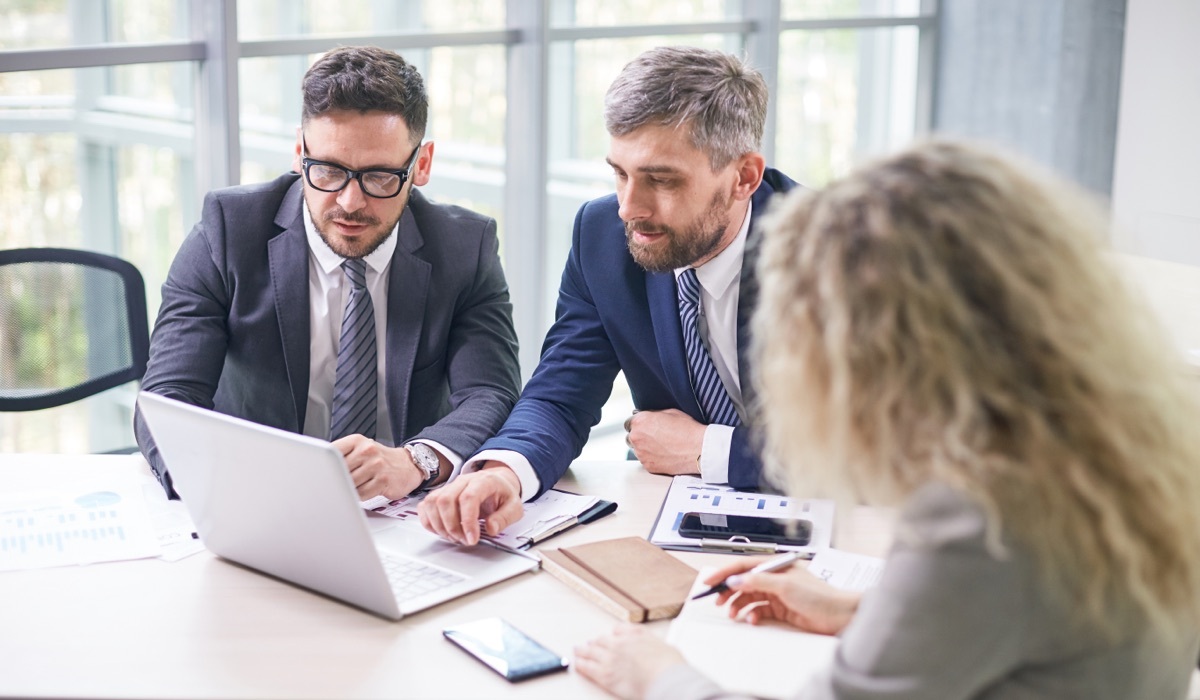 Accountants sitting at a table processing payables.